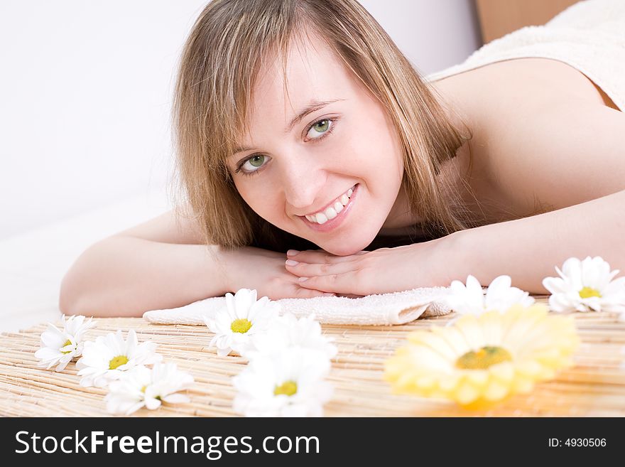 Portrait of fresh and beautiful young woman laying on bamboo mat / taking spa treatment. Portrait of fresh and beautiful young woman laying on bamboo mat / taking spa treatment