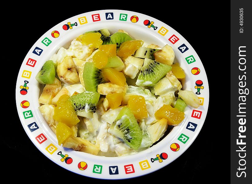 Fruit salad in a plate isolated on a black background