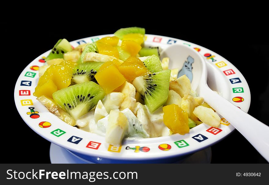 Fruit salad in a plate on a black background