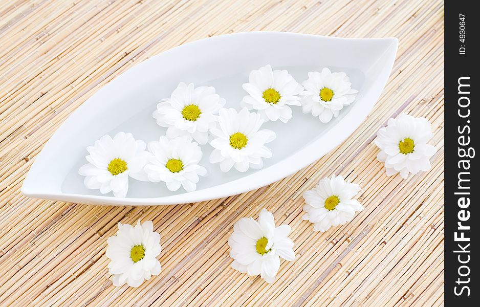 Fresh flowers in the bowl on the bamboo mat / daisies. Fresh flowers in the bowl on the bamboo mat / daisies