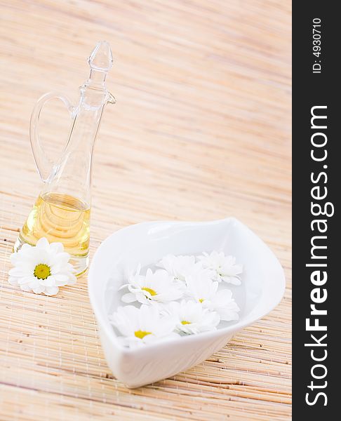 Bottle of essential oil and daisies