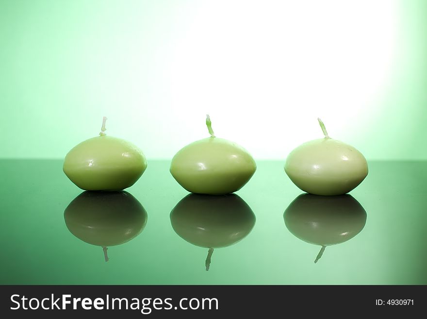 Three candles on the green background / copyspace. Three candles on the green background / copyspace