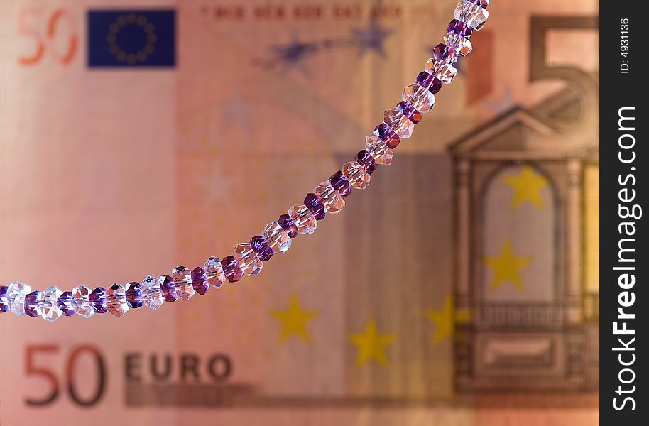 Necklace on a background of a banknote. Shallow depth of field. Necklace on a background of a banknote. Shallow depth of field.