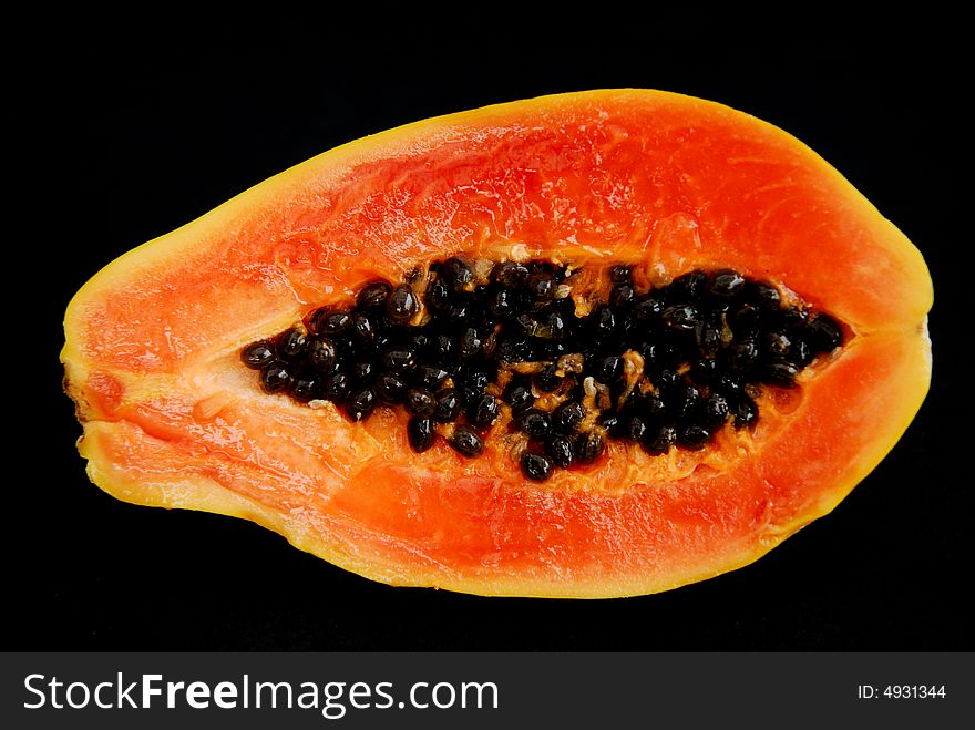 Ripe Papaya cut in half and isolated on black.