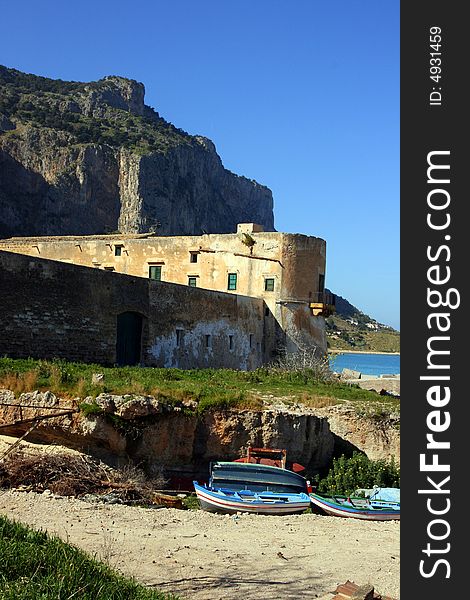 Ancient Tuna fishing construction Tonnara Bordonaro XVI century in Palermo. View on Mount Pellegrino blue sky and sea. Island of Sicily, Italy. Ancient Tuna fishing construction Tonnara Bordonaro XVI century in Palermo. View on Mount Pellegrino blue sky and sea. Island of Sicily, Italy