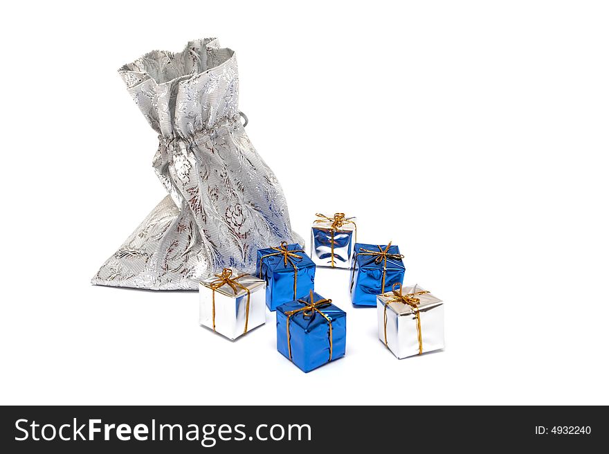 The gifts which are dropping out of a silver bag on a white background. The gifts which are dropping out of a silver bag on a white background