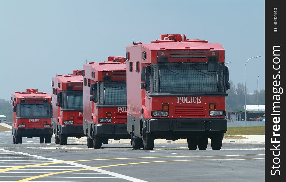 Four armoured, red police trucks, special forces for riot control etc. Shallow depth of field with the two first cars in focus. Four armoured, red police trucks, special forces for riot control etc. Shallow depth of field with the two first cars in focus.