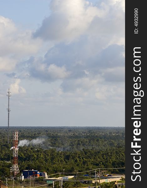 Radio tower with smoke in distance and green trees on cozumel mexicon yucatan peninsula. Radio tower with smoke in distance and green trees on cozumel mexicon yucatan peninsula