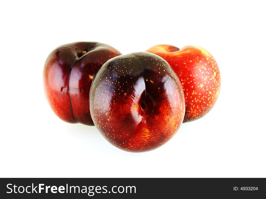 Three fresh ripe sweet plums over white background