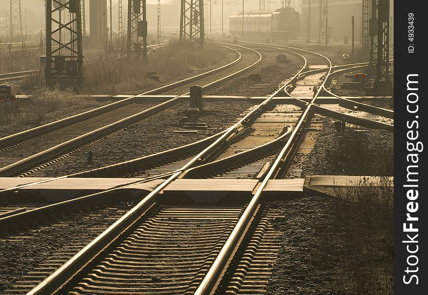 Train reaching approaching a railway station in early morning sunlight. Train reaching approaching a railway station in early morning sunlight