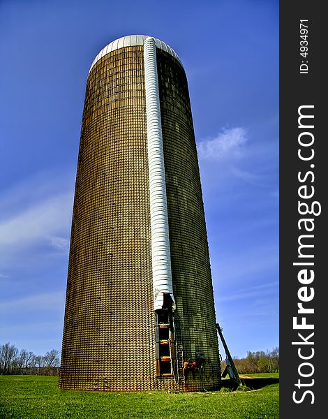 Close up of a grain silo sitting in the middle of a big field on a livestock plantation. Close up of a grain silo sitting in the middle of a big field on a livestock plantation.