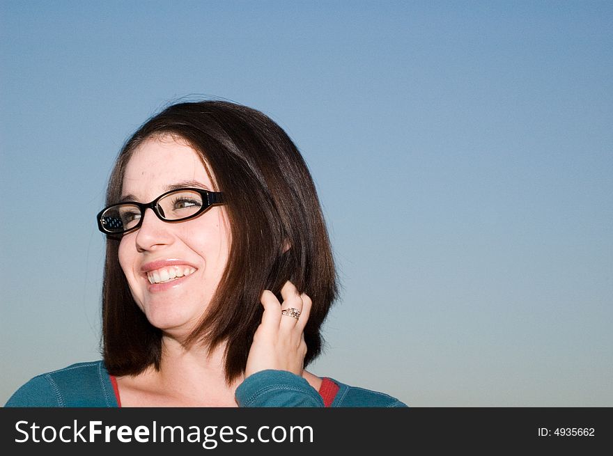 Portrait of a smiling girl with glasses against the background of a clear blue sky. . Portrait of a smiling girl with glasses against the background of a clear blue sky.