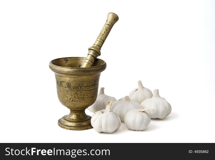 Bronze mortar with bulbs of garlic, isolated on white background