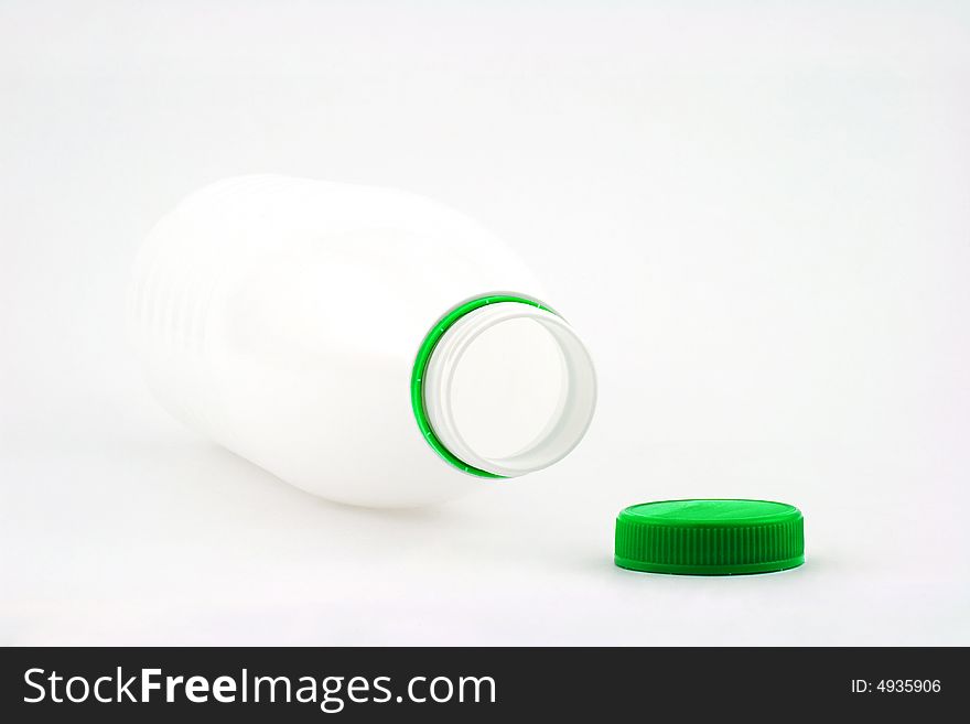 Photo of white bottle with green cover on white background