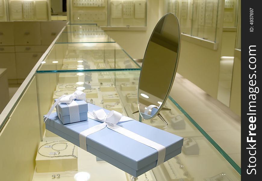 Present gift in jewerly shop. Blue boxes for jewerly near the mirror