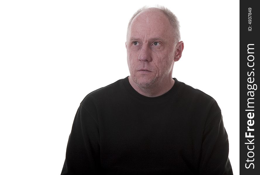 An older guy in a black shirt with a serious expression looking into copy space. An older guy in a black shirt with a serious expression looking into copy space