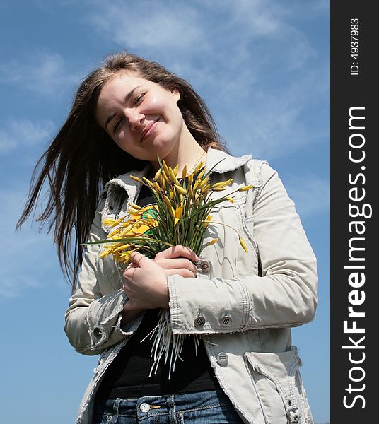 Beautiful young girl with flowers and blue sky. Beautiful young girl with flowers and blue sky