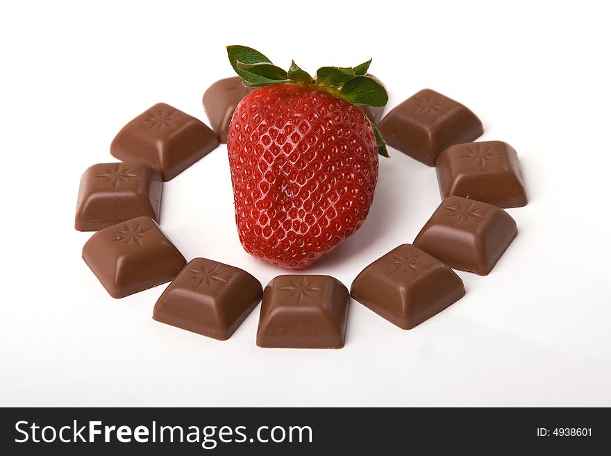 A photo of little chocolate bars around trawberry. A photo of little chocolate bars around trawberry