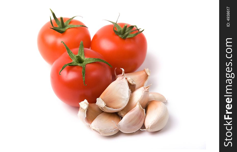 A photo of three tomatoes with garlic on salad. A photo of three tomatoes with garlic on salad