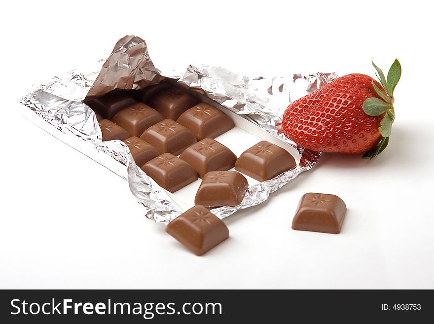 A photo of strawberry and a bar of chocolate. A photo of strawberry and a bar of chocolate