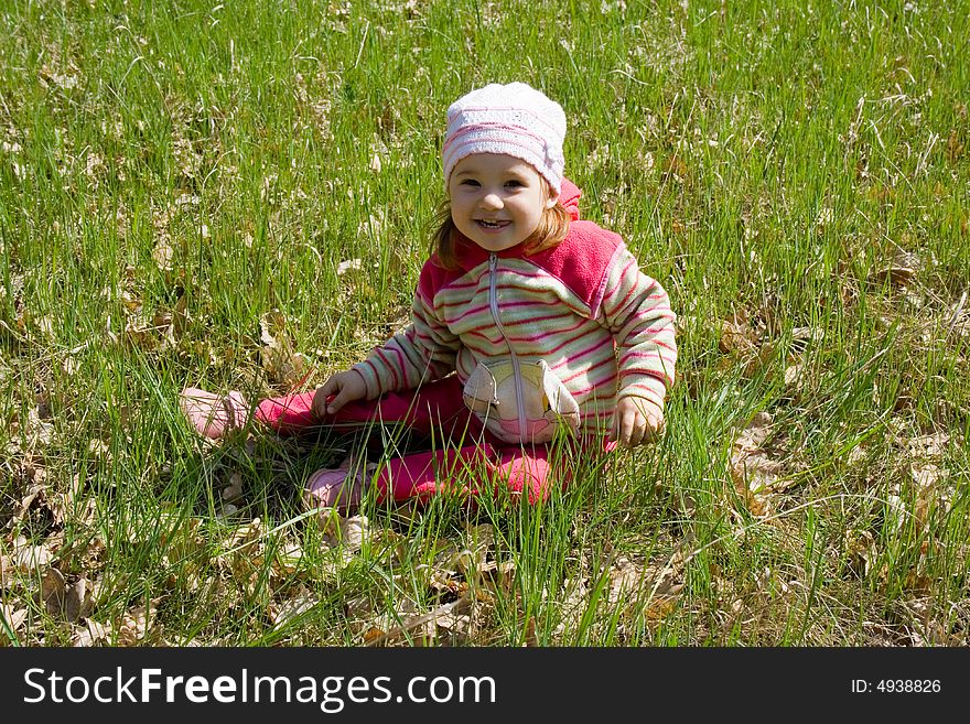 Little nice girl sitting on green grass. Little nice girl sitting on green grass