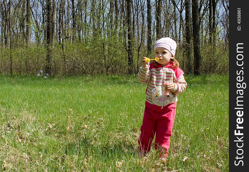 Nice child blowing soap bubbles