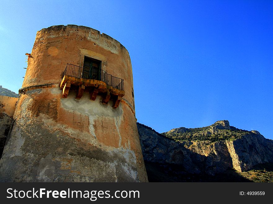 Ancient Tuna fishing construction Tonnara Bordonaro XVI century in Palermo. View on Mount Pellegrino blue sky and sea. Island of Sicily, Italy. Ancient Tuna fishing construction Tonnara Bordonaro XVI century in Palermo. View on Mount Pellegrino blue sky and sea. Island of Sicily, Italy