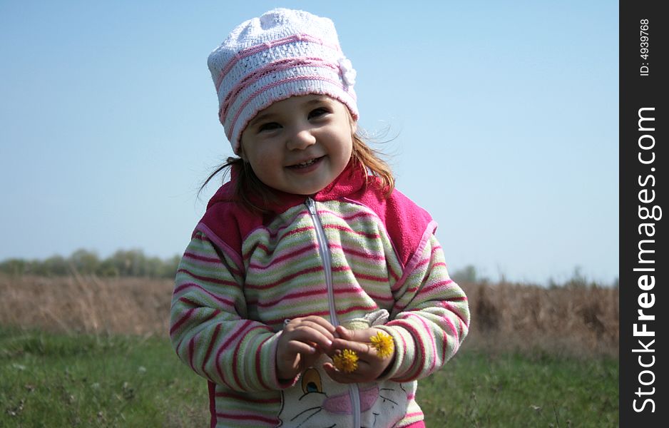 Smiling little girl playing on the meadow