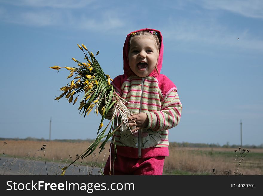 Little cute girl with bunch of flowers laughing. Little cute girl with bunch of flowers laughing