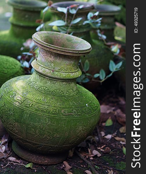 Green, ancient Buddhist vases with inscriptions and ornaments.