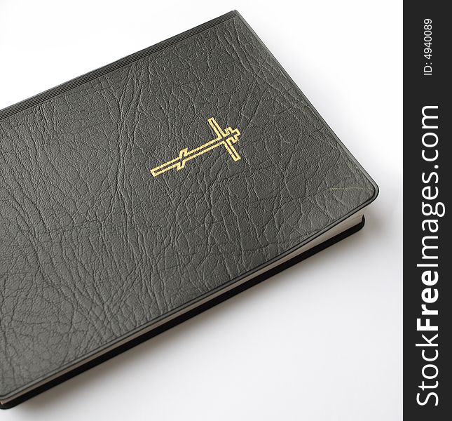 Black leather-bound bible lying on white background