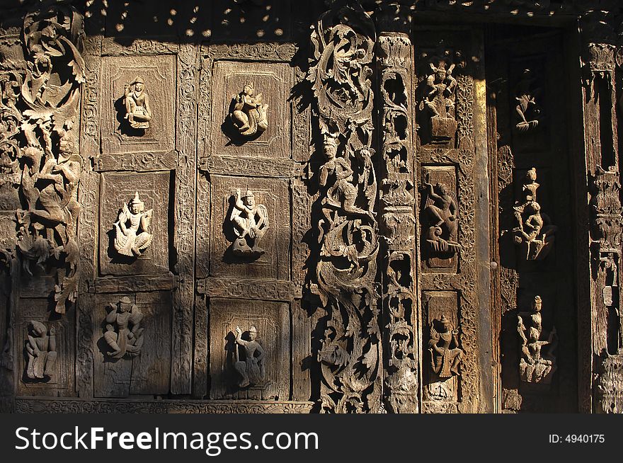 Myanmar, Mandalay: Pagoda; detail of the ancient architecture of this wood monastery; carved religious figures