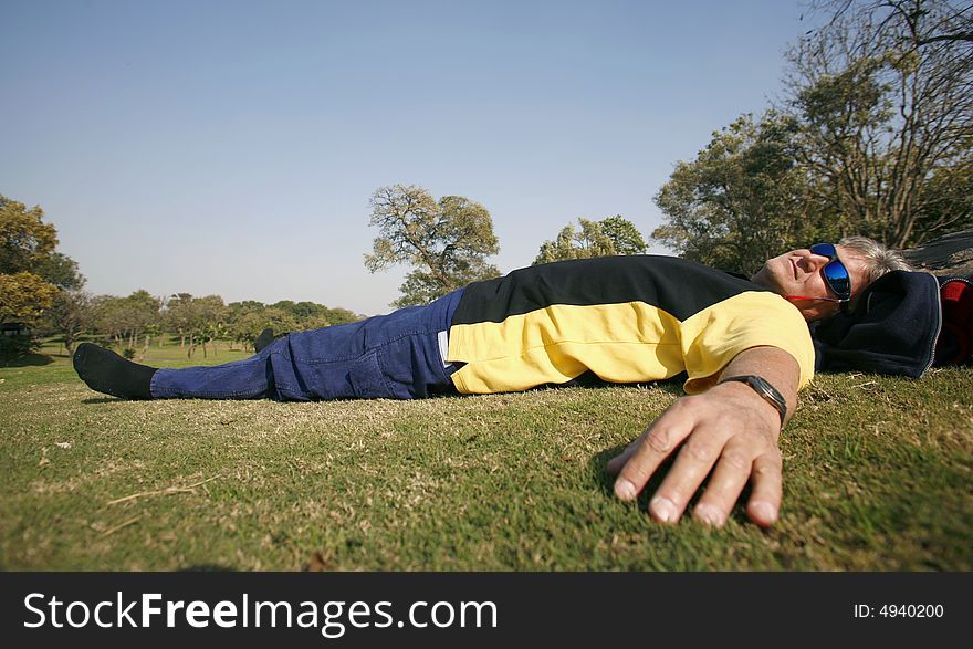Man in park relaxing in grass