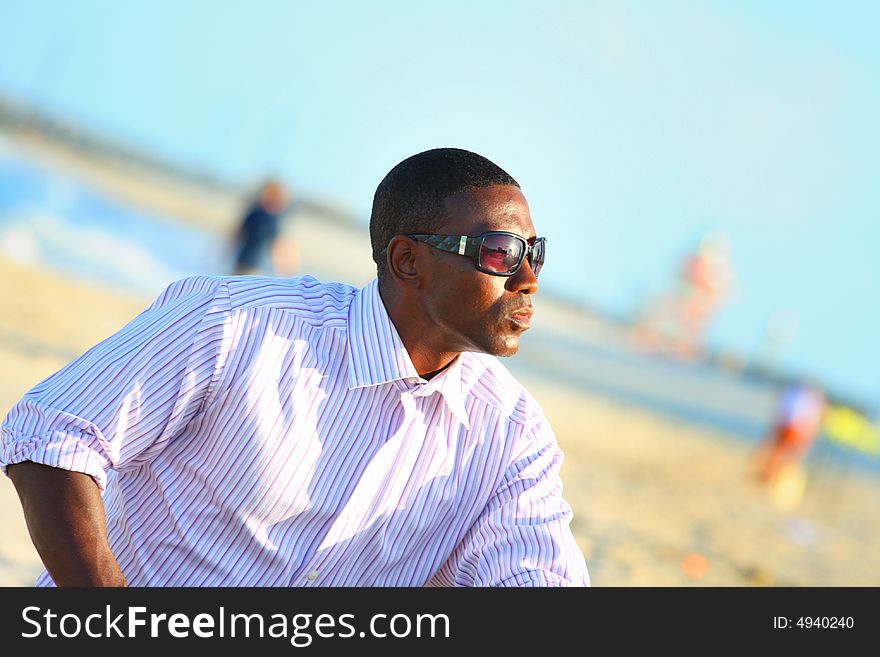 Young black businessman on the beach.