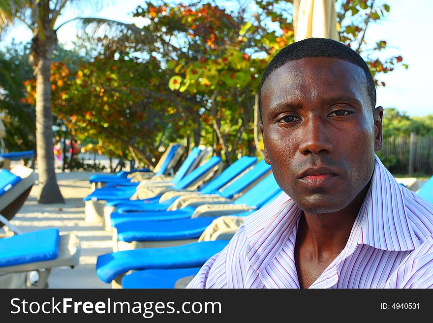 Attractive young black man lounging by a resort. Attractive young black man lounging by a resort.