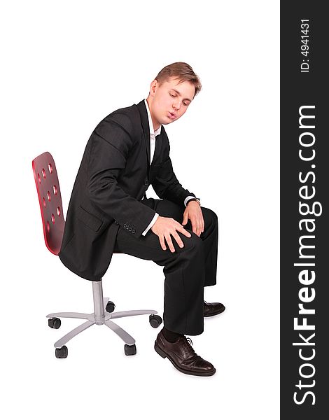 Young man in suit sits on chair on a white
