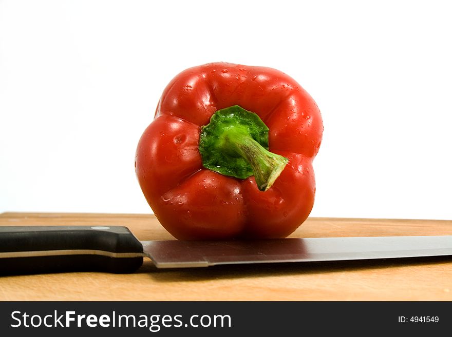 Red pepper and knife isolated on white