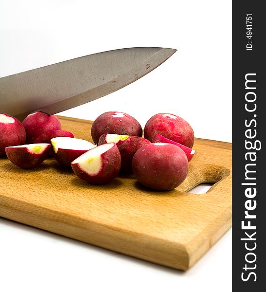 Radish and knife on wooden plate isolated