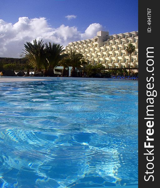 Blue pool water with a palms and hotel. Blue pool water with a palms and hotel