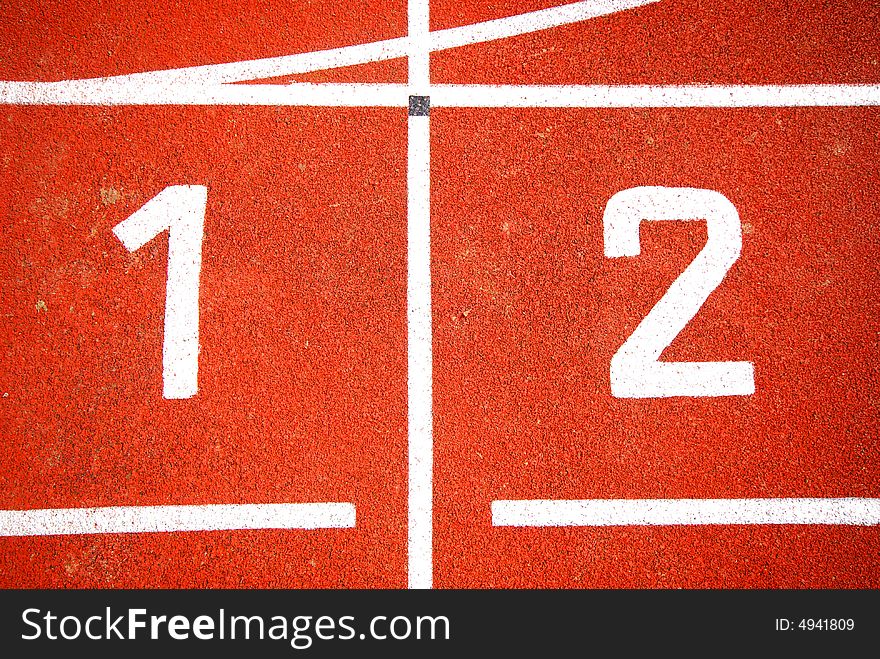 First two numbers of a racetrack, on red tarmac, for runners