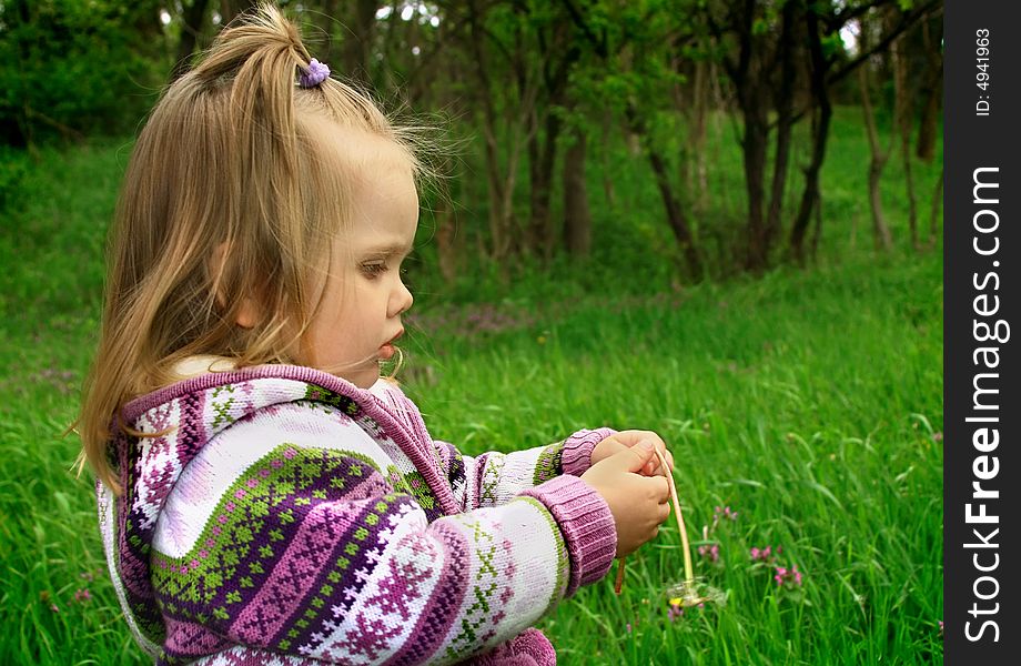 Little Girl Walks In The Spring On A Young Grass