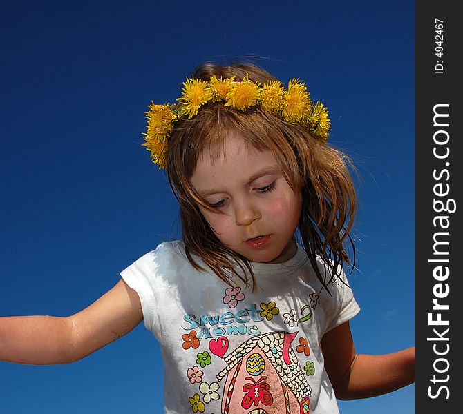 Girl wearing a dandelion diadem on a sand beach