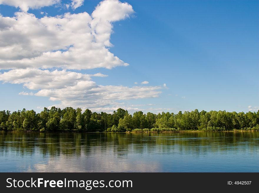 Landscape series: river and forest ander blu cloudy sky