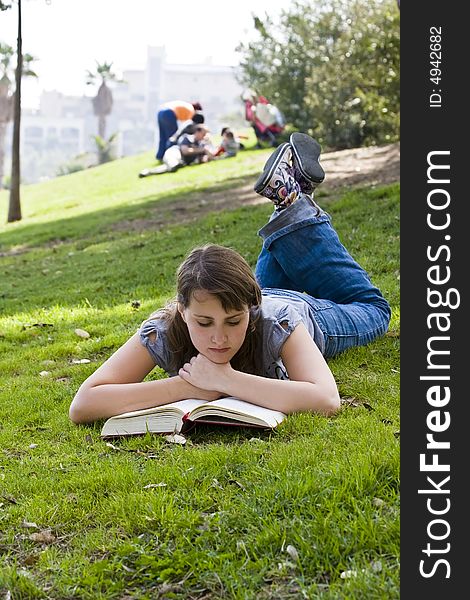 Young woman reading over the grass. Young woman reading over the grass.