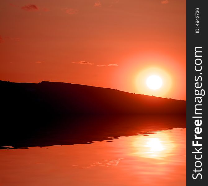 Sunset with clouds in orange and golden light reflected in water. Sunset with clouds in orange and golden light reflected in water