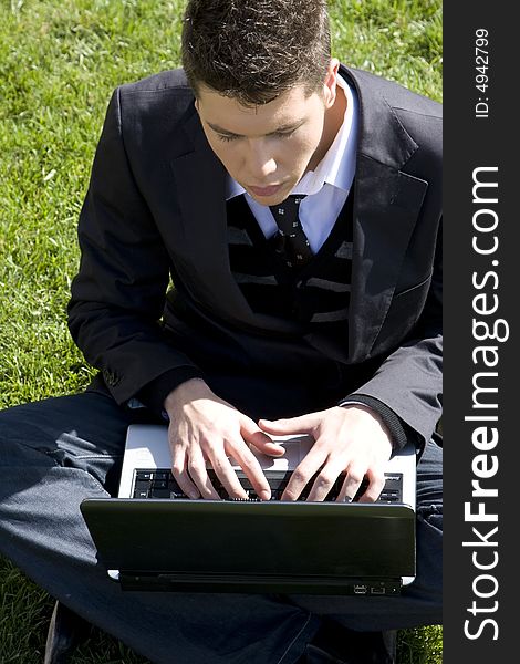 Outdoors working businessman on green grass