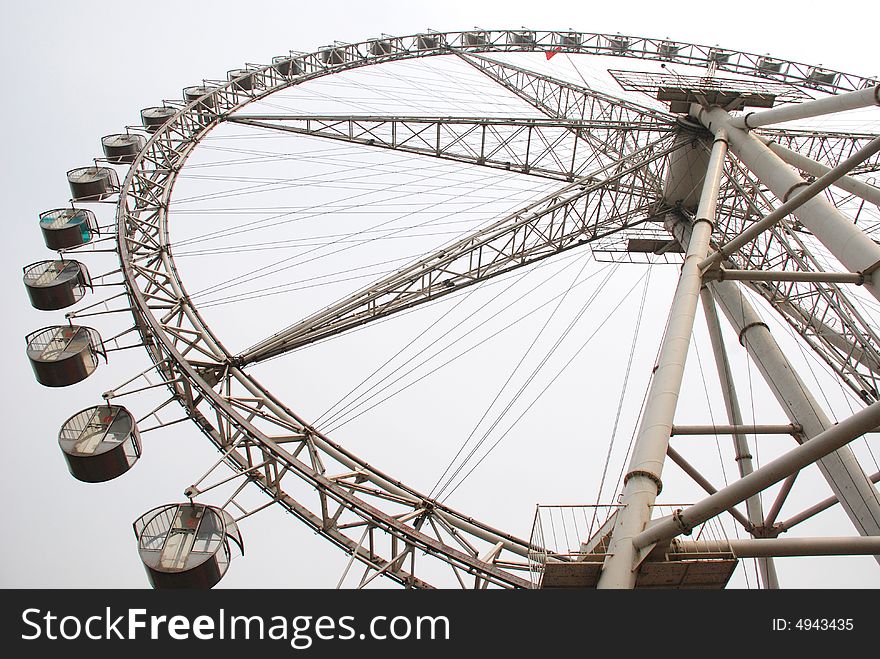 The great steel Ferris wheel in an amusement park. The great steel Ferris wheel in an amusement park.