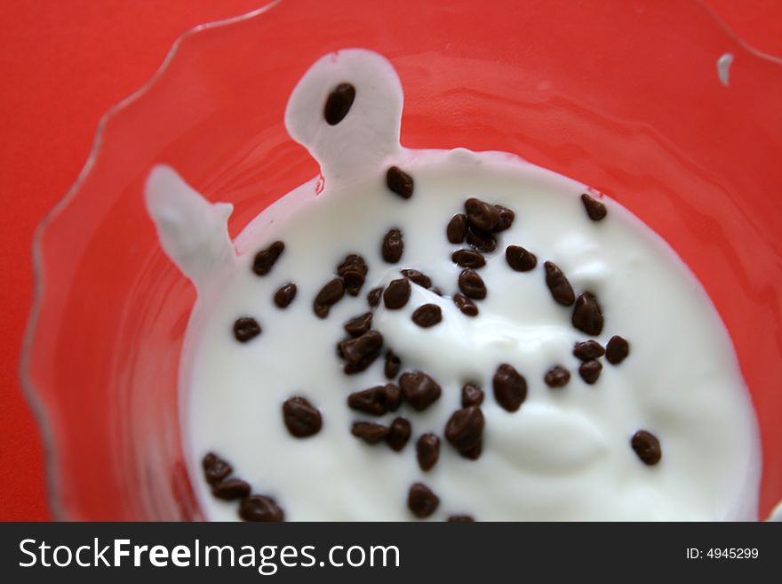 Yogurt (yoghurt) with chocolate in dish on the red background,
selective focus