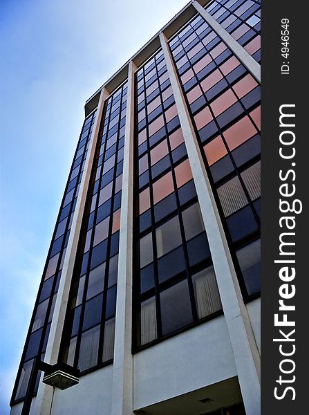 Office building in the early morning. Wide-angle lens used to distort perspective and make the building appear to tower more imposingly. Office building in the early morning. Wide-angle lens used to distort perspective and make the building appear to tower more imposingly