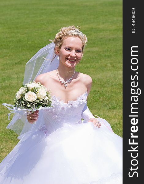 Blond bride runs with bouquet of white roses. Blond bride runs with bouquet of white roses